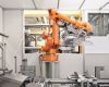 A robotic arm transports plastic cover lenses